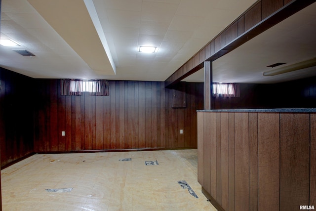 basement featuring wooden walls