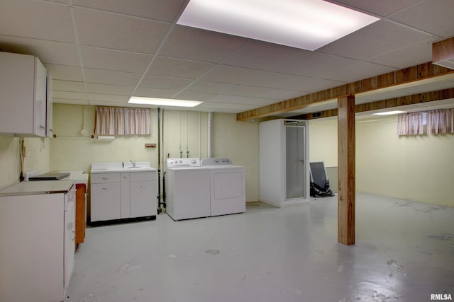 basement featuring sink, washing machine and clothes dryer, and a paneled ceiling