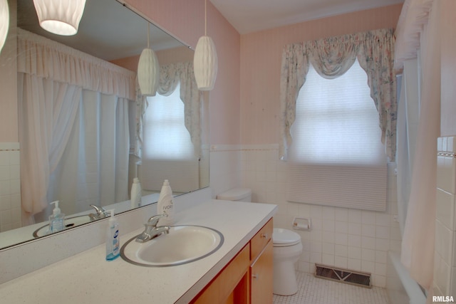 full bathroom featuring tile patterned floors, tile walls, toilet, vanity, and shower / bathtub combination with curtain