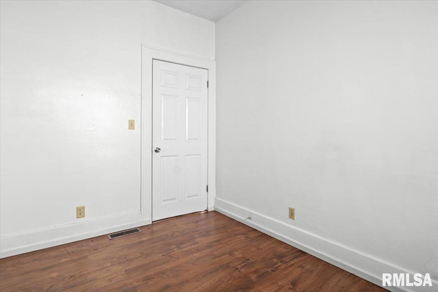 unfurnished room with dark wood-type flooring