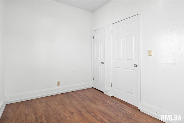 unfurnished bedroom with dark hardwood / wood-style flooring