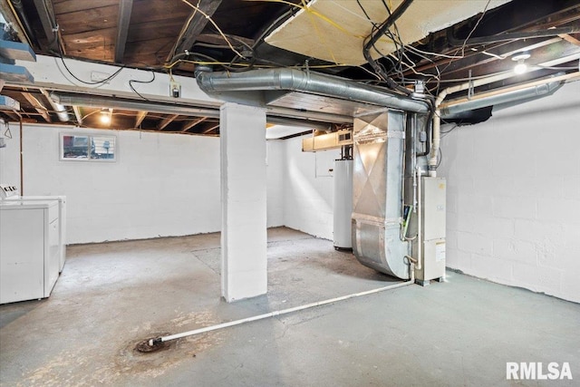 basement with washing machine and dryer, heating unit, and gas water heater