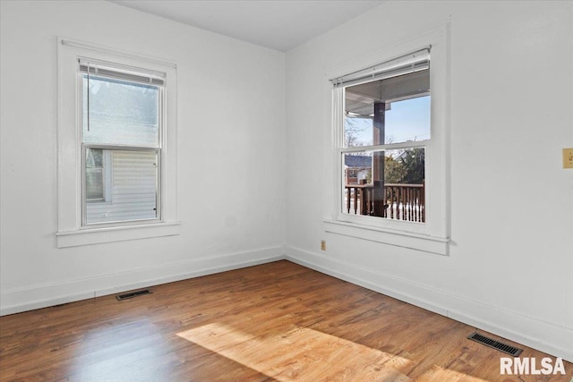 unfurnished room featuring hardwood / wood-style flooring and plenty of natural light