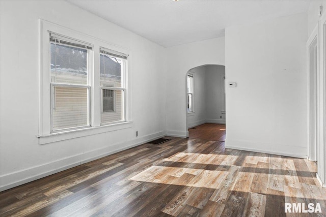 unfurnished room with dark wood-type flooring and a healthy amount of sunlight