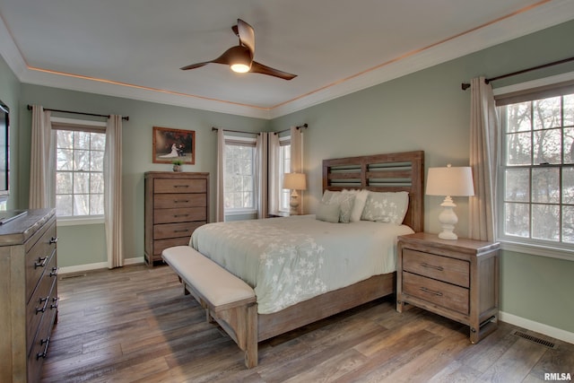 bedroom with ceiling fan, crown molding, and wood-type flooring