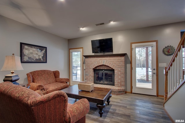 living room featuring wood-type flooring and a fireplace