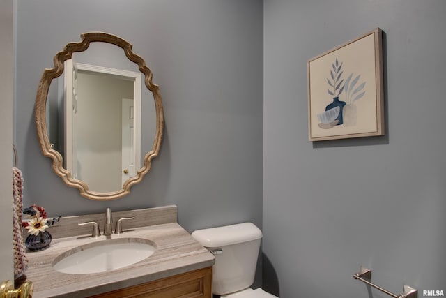 bathroom featuring toilet and vanity