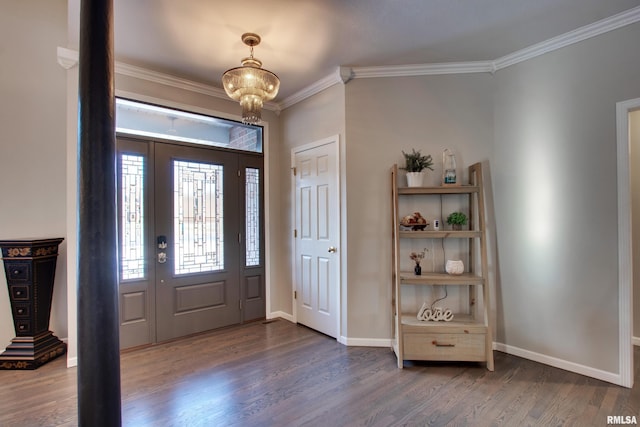 foyer with ornamental molding, dark wood-type flooring, and an inviting chandelier