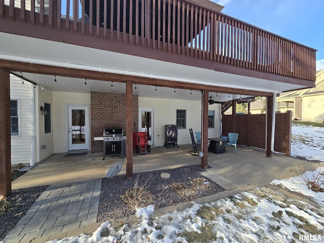 snow covered patio with ceiling fan and grilling area