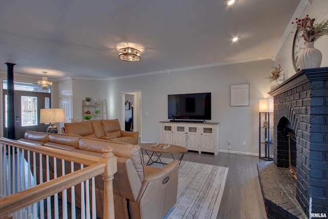 living room with a chandelier, crown molding, dark hardwood / wood-style floors, and a fireplace