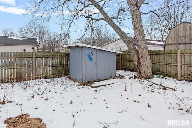 snowy yard featuring a storage shed