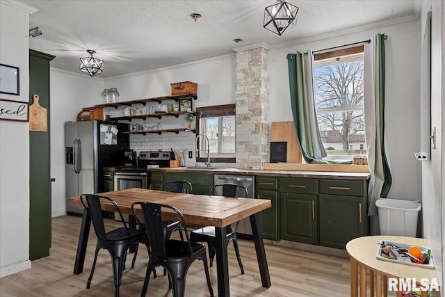 kitchen featuring sink, a textured ceiling, stainless steel appliances, and a healthy amount of sunlight