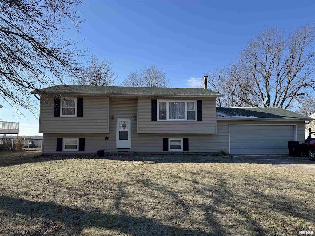 split foyer home with a garage and a front yard