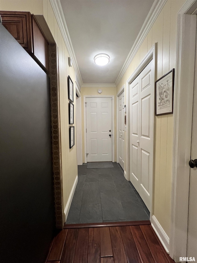 hall with dark wood-type flooring and crown molding