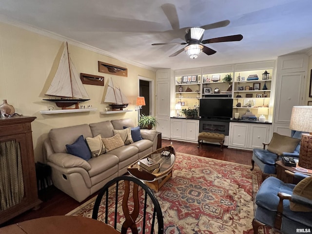 living room with ceiling fan, dark wood-type flooring, built in features, and crown molding