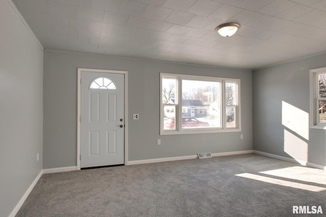 entryway featuring crown molding and light colored carpet