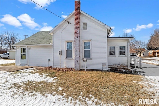 view of snow covered rear of property