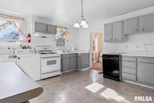 kitchen with dishwasher, gray cabinetry, washing machine and clothes dryer, white range with gas cooktop, and decorative light fixtures