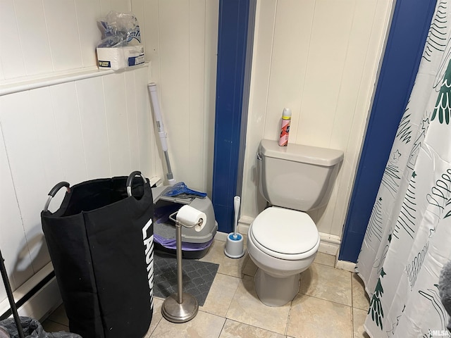238 E Prairie St, Roodhouse, IL 62082 - bathroom featuring toilet, tile patterned flooring, and wood walls