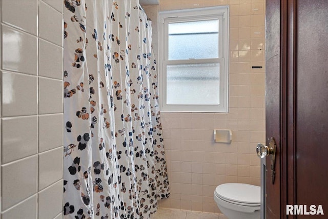 bathroom featuring walk in shower, tile walls, and toilet