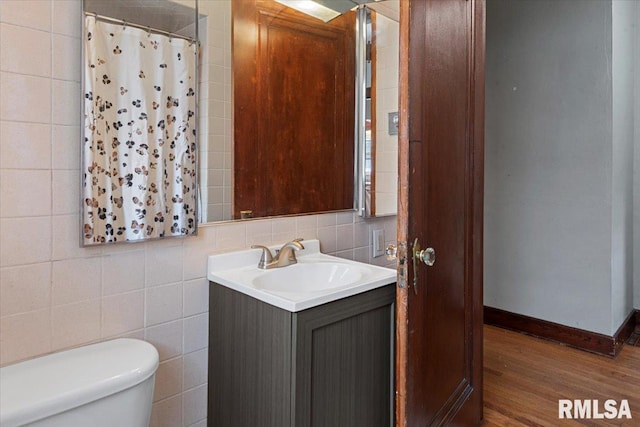 bathroom with toilet, tile walls, vanity, a shower with shower curtain, and hardwood / wood-style flooring