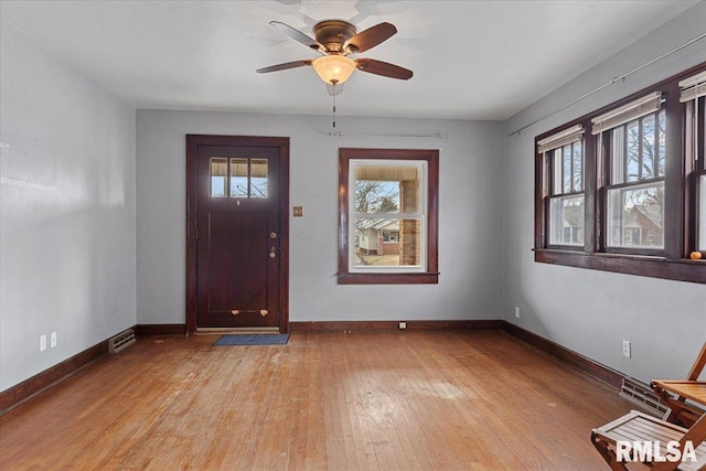 foyer featuring plenty of natural light, ceiling fan, and light wood-type flooring