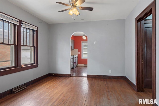 unfurnished room featuring dark hardwood / wood-style floors, a wealth of natural light, and ceiling fan