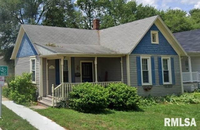 view of front of house with a porch and a front yard