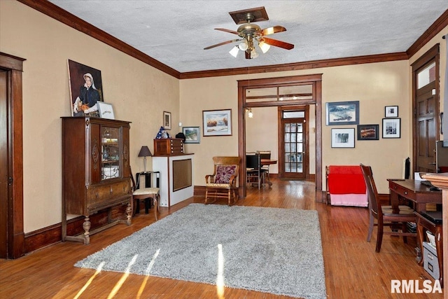 living area featuring french doors, crown molding, a textured ceiling, hardwood / wood-style flooring, and ceiling fan