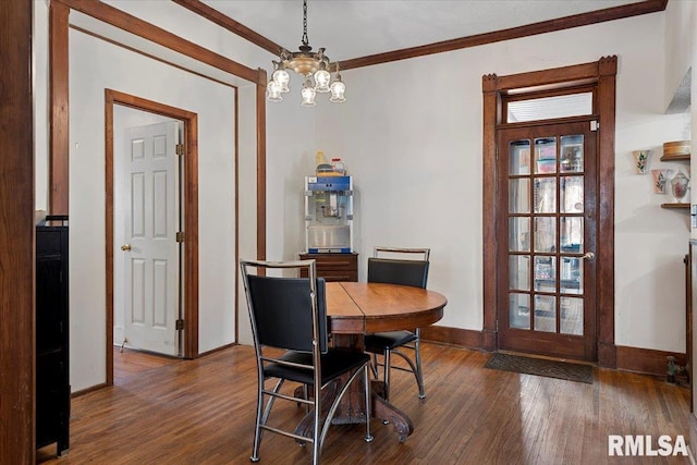 dining room with crown molding, dark hardwood / wood-style floors, and a chandelier