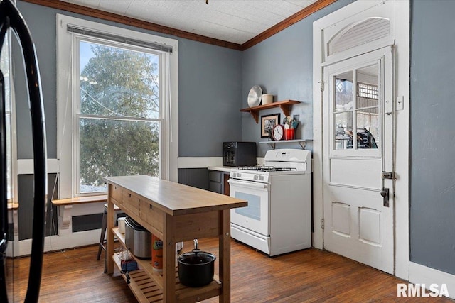 kitchen with dark hardwood / wood-style flooring, ornamental molding, and gas range gas stove