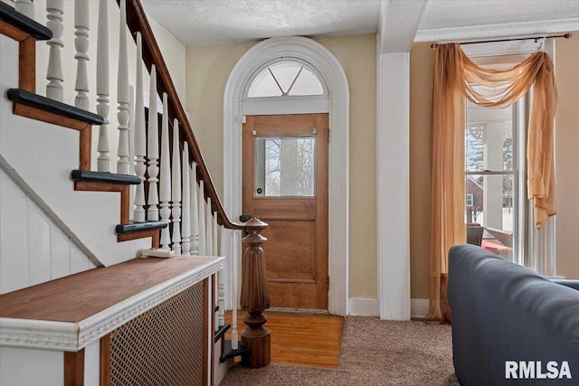 foyer with carpet floors and a textured ceiling