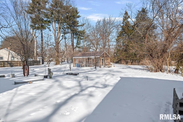 yard covered in snow with an outbuilding