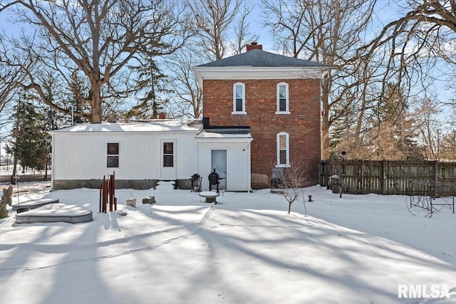 view of snow covered back of property