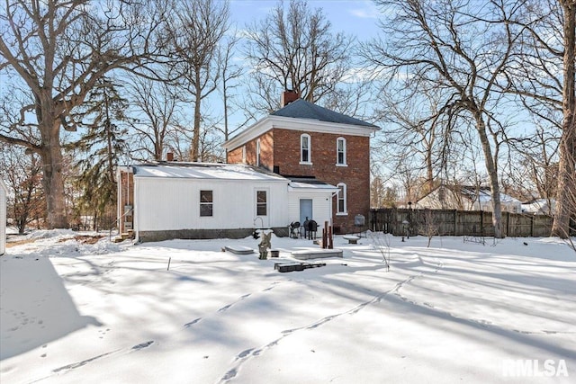 view of snow covered back of property