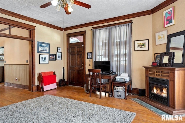 entrance foyer with hardwood / wood-style flooring, ornamental molding, ceiling fan, and a textured ceiling