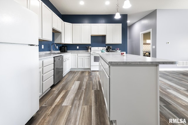 kitchen featuring white cabinetry, sink, pendant lighting, and white appliances