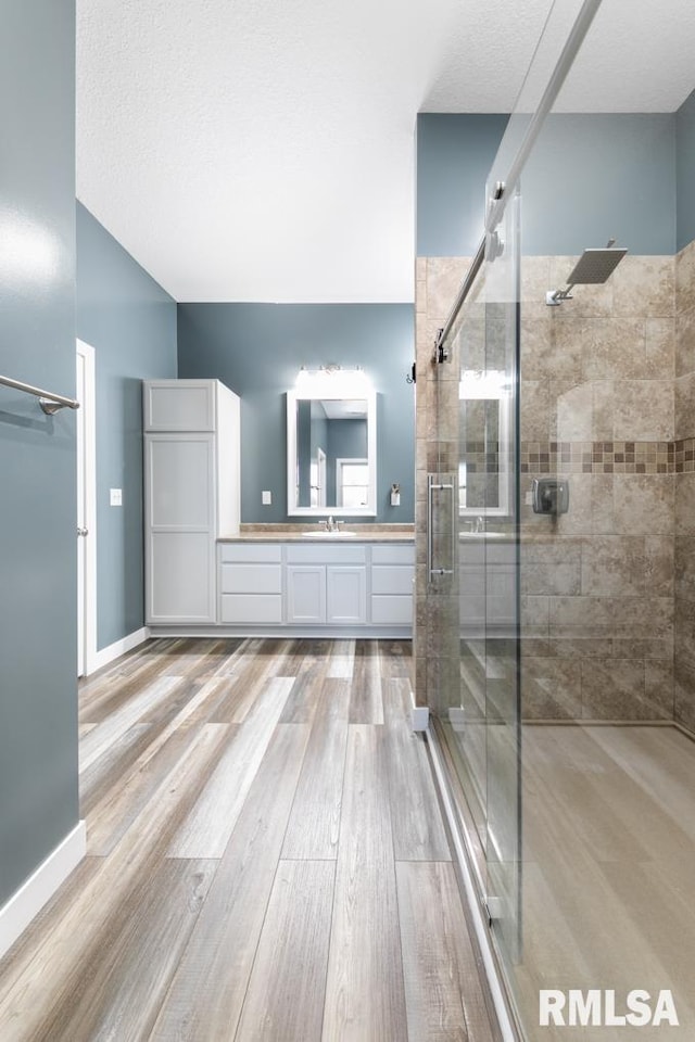 bathroom with vanity, an enclosed shower, and hardwood / wood-style flooring