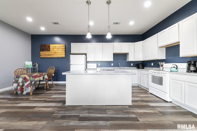 kitchen featuring white appliances, decorative light fixtures, a center island, and white cabinets