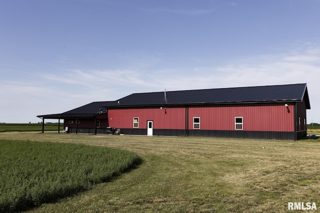 view of side of home with an outbuilding and a yard