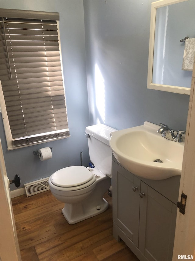 bathroom with hardwood / wood-style flooring, vanity, and toilet