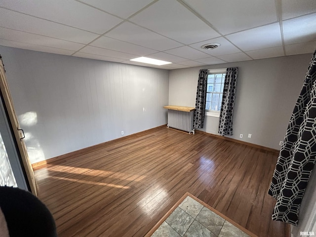 empty room featuring hardwood / wood-style flooring and a paneled ceiling