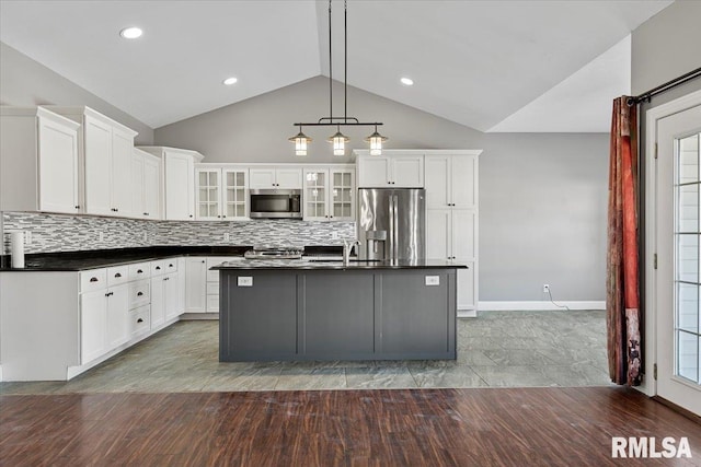 kitchen with stainless steel appliances, white cabinetry, and decorative light fixtures