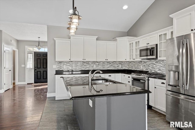 kitchen featuring appliances with stainless steel finishes, decorative light fixtures, a kitchen island with sink, and white cabinets