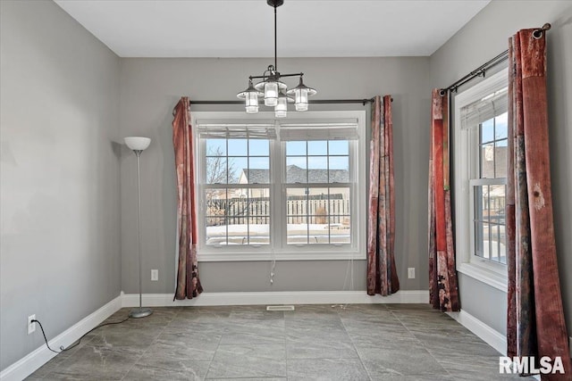 unfurnished dining area featuring an inviting chandelier