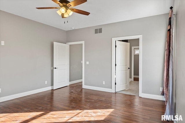 unfurnished bedroom featuring dark wood-type flooring and ceiling fan