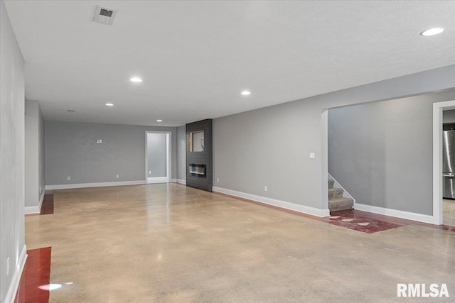 unfurnished living room featuring a large fireplace and a textured ceiling