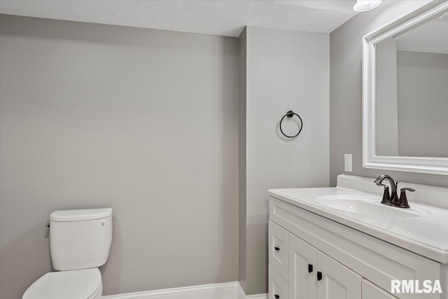 bathroom featuring vanity, toilet, and a textured ceiling