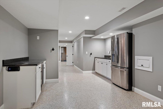 kitchen featuring white cabinetry and stainless steel fridge with ice dispenser