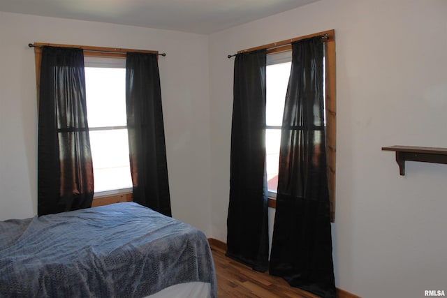 bedroom with multiple windows and hardwood / wood-style floors